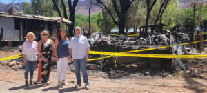 Board members of the Southeastern Utah Chapter of Realtors stand in front of the mobile homes that were destroyed in the June 5, 2022, fire.